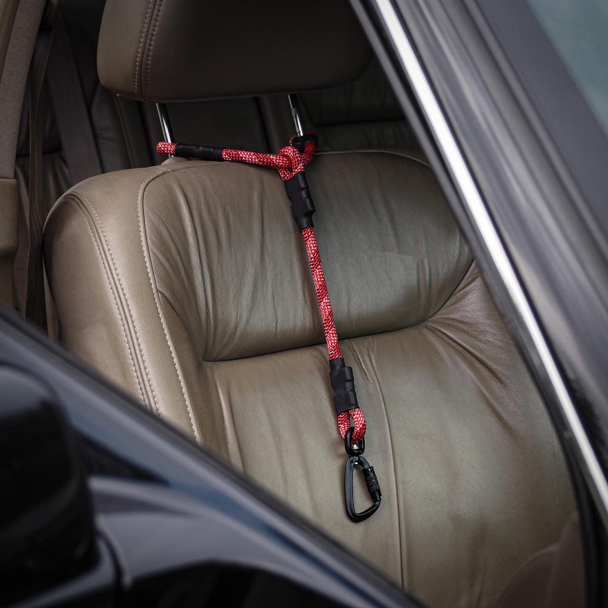 Climbing rope car headrest attachment, looped securely around metal headrest poles inside a vehicle, showcasing a minimalist and functional design.